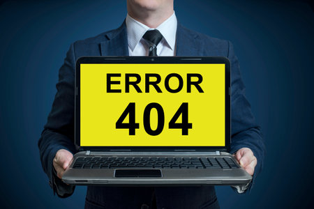Businessman holding a laptop with a message error 404の写真素材