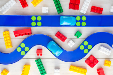 Toy car, plastic road and colorful blocks on white wooden backgroundの写真素材