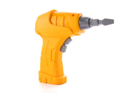Yellow plastic toy drill screwdriver with bit isolated on white backgroundの写真素材