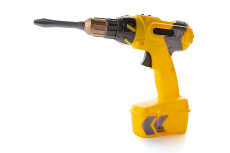 Yellow plastic toy drill screwdriver with bit isolated on white backgroundの写真素材