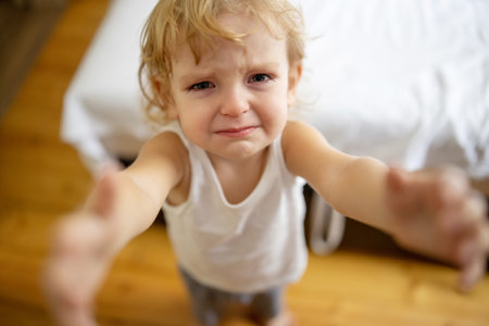 Cute little blond child is crying. Crying child, stress, pain, sadness, despairの写真素材