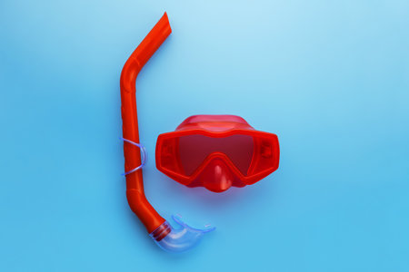 A set of red swimming mask and snorkel on a blue backgroundの写真素材