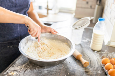 Baking concept. Woman in apron kneading dough for homemade pastries in kitchen