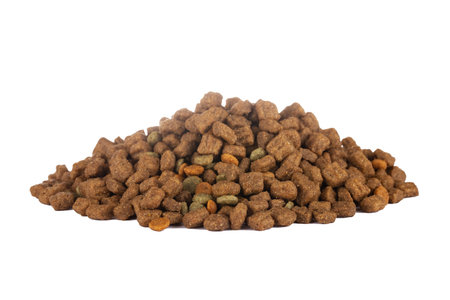 Brown crunchy organic kibble pieces for dog feed heap isolated on whiteの写真素材