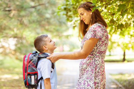 Back to school. Mother saying goodbye to her son as he leave for School.の写真素材