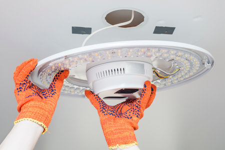 An electrician installs a chandelier on the ceiling.の写真素材