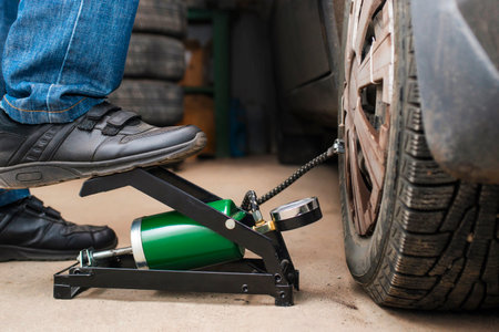 Auto mechanic tightening the nuts with a wheel wrench. Seasonal tire changeの写真素材