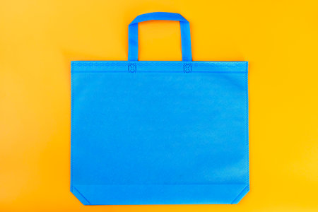 The blue shopping bag on a yellow background. Mockup for design.の写真素材