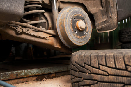 Car on tire mounting with removed wheel. Wheel hub closeup.の写真素材