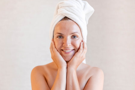 Closeup portrait of beautiful young woman with towel on head.の写真素材