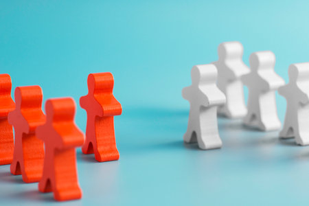 Two groups of wooden figures are standing in front of each other.の写真素材