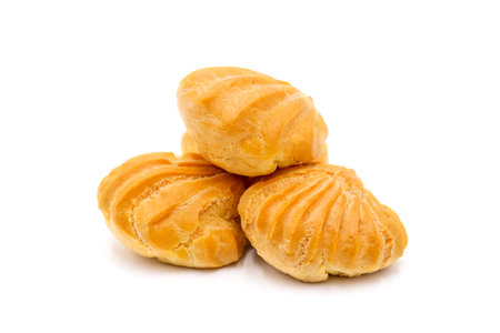 Three whole baked golden profiterole in line isolated on white background