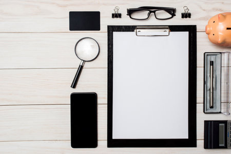 Work from home. Workspace with smartphone, pen, glasses, calculator, magnifier