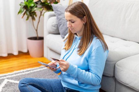 Casual Woman Browsing on Smartphone at Homeの写真素材