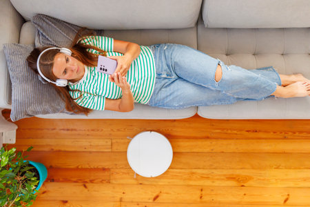 Woman Relaxing with Music and Smartphone at Homeの写真素材