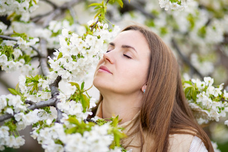 Woman Enjoying the Scent of Spring Blossomsの写真素材
