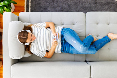 Relaxed Woman Listening to Music on Couchの写真素材