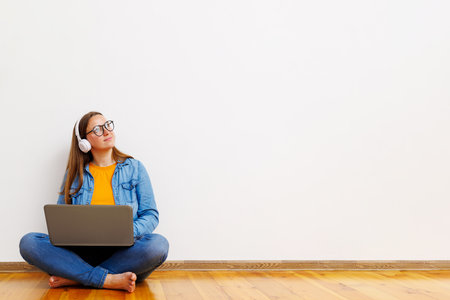 Young Woman Enjoying Music on Laptop at Homeの写真素材