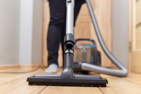 Person vacuuming floor. Household chore and cleaning concept.の写真素材