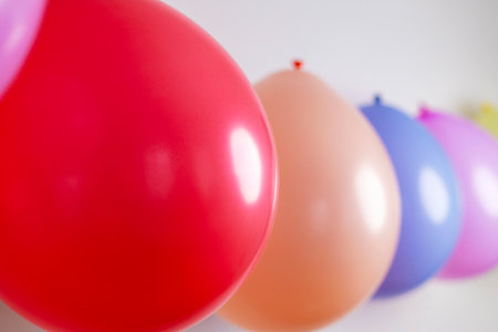 Multicolored balloons in a row with selective focus on a red balloonの写真素材