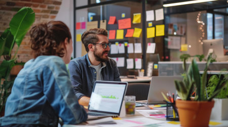 Founder interviewing candidate in startup office. Digital boards and laptops in a creative workspace. Modern tech company atmosphere.の素材