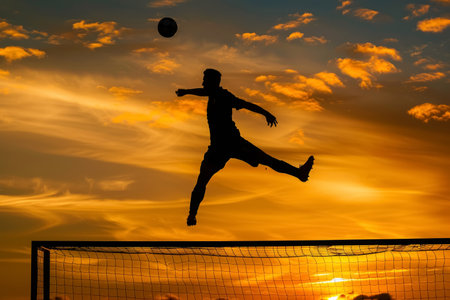 Silhouette of a soccer player heading a ball at sunset. Dramatic outdoor sports scene with a golden sky. Football training concept for banner and poster design.の素材