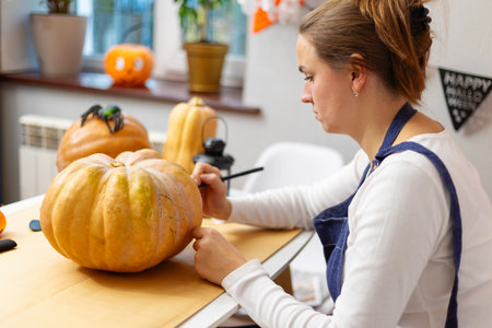 Woman Carving Pumpkin for Halloween Decorationsの写真素材