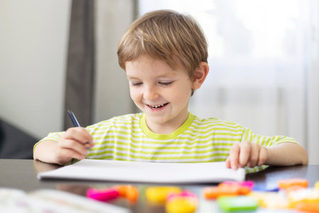 Child drawing with colored pencils at homeの写真素材