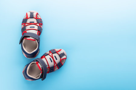 Pair of childrens sandals on blue backgroundの写真素材