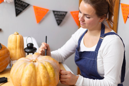 Woman Decorating Pumpkin for Halloween Eventの写真素材