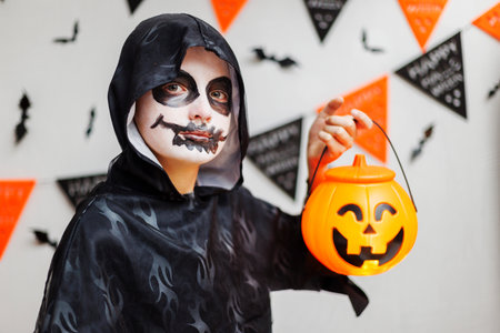 Child in Spooky Costume with Halloween Candyの写真素材