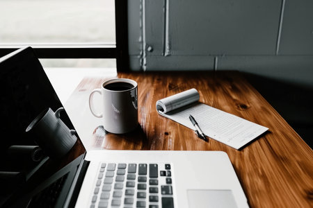 Modern Office Desk with Laptop Displaying Black Friday Deals for Business Equipmentの素材