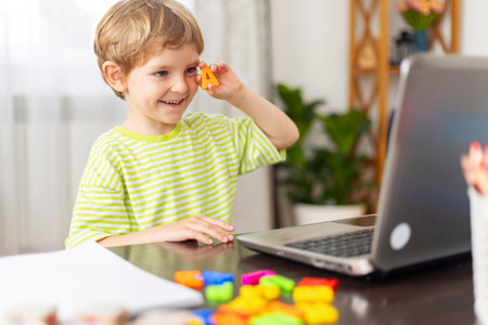 Child learning online with laptop and toysの写真素材