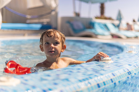 Boy relaxing in swimming pool outdoorsの写真素材