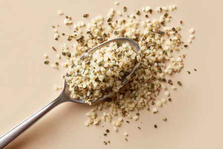 Hemp Seeds on Spoon Spilled on Solid Background for Nutritional Conceptの素材