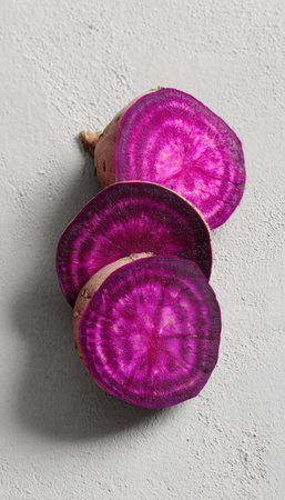 Vibrant Sliced Purple Sweet Potato on Light Gray Backgroundの素材