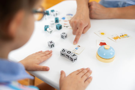 Child Learning with Alphabet Blocks and Flashcards at Table