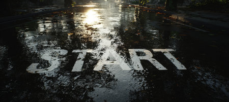 Wet asphalt with "START" marking reflects trees and sunlight, creating a cinematic and symbolic scene of fresh beginnings after rain. The image captures realism and renewal.の素材