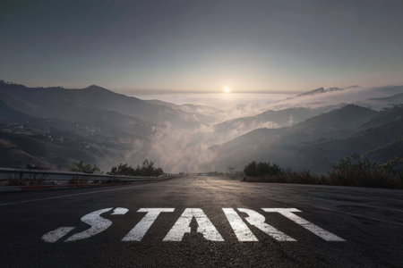 Cinematic view of a mountain road with "START" text, illuminated by sunrise light. Misty hills create a motivational and realistic HDR landscape, perfect for inspiration.の素材