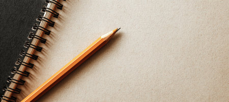 A minimalist image featuring a notebook and pencil in the bottom corner, with a softly textured background ideal for quote or announcement overlays.の素材