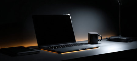 A sleek black workspace featuring a glowing laptop screen, creating a high-contrast, high-end advertising look. Ideal for showcasing premium tech products in a minimalist setting.の素材