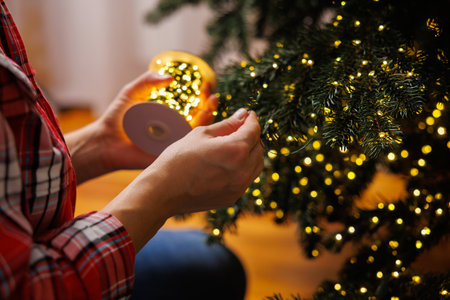 Decorating Christmas Tree with Warm White String Lightsの写真素材