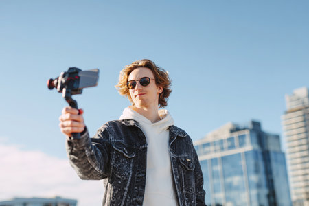 Content Creator Filming Vlog with Smartphone Stabilizer in Urban Settingの素材