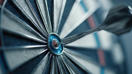 Conceptual macro image of a dart hitting the bullseye, symbolizing focus and precision. Features a clean, modern background with blue tones, highlighting accuracy and determination.の素材