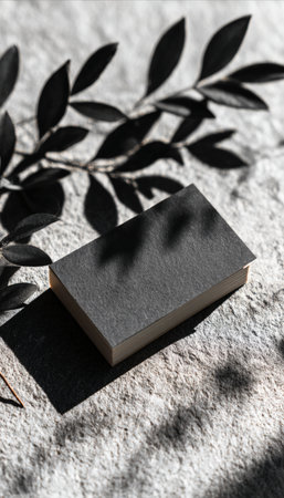 Stylish business card mockup on a stone surface with leaves casting natural shadows. The top-down soft light enhances the minimalist design, ideal for branding presentations.の素材