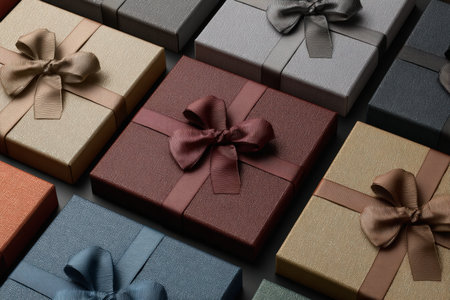 Close-up of luxurious gift boxes arranged in a grid, featuring matte paper and silk bows. The subtle textures and elegant design highlight high-end product presentation.の素材