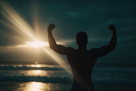 Silhouette of an athlete celebrating a successful morning workout by the ocean. Glowing light beams and cinematic focus create a dramatic and inspiring scene.の素材