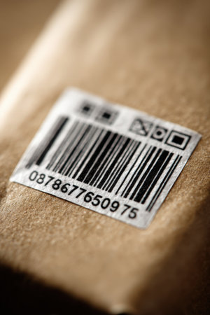 Close-up macro photograph of a package label featuring a tracking code. The image showcases a minimal composition with a soft depth of field, highlighting industrial details.の素材