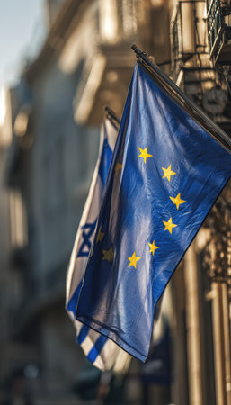 European Union and Israel flags are displayed together in warm daylight, symbolizing diplomatic relations. The EU flag's blue and gold contrasts with Israel's blue Star of David.の素材