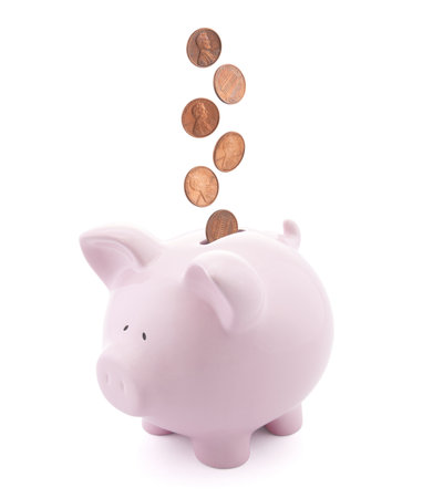 Piggy bank with coins falling into slot Piggy bank with coins falling into slot